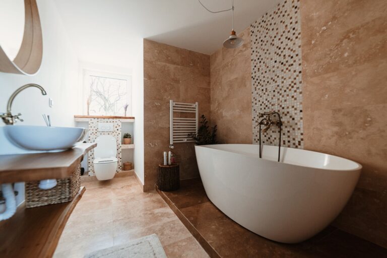 Bathroom remodel with freestanding soaking tub and natural stone tile