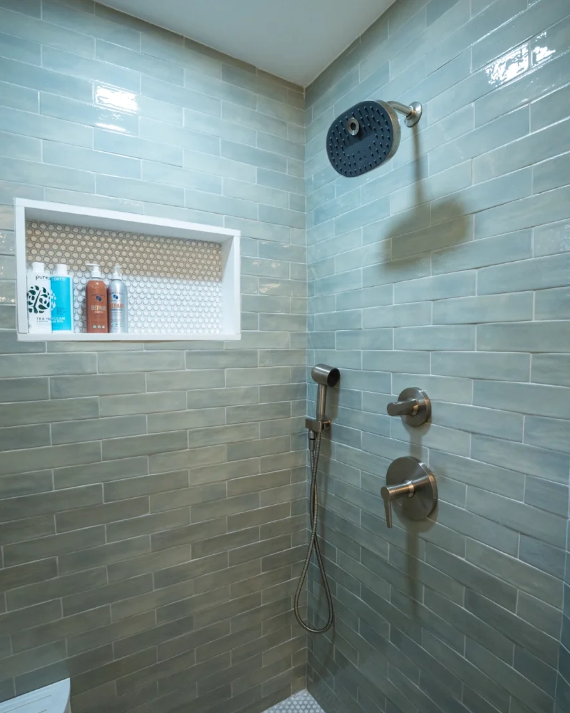 Walk-in shower with sage green tile, niche and rain showerhead