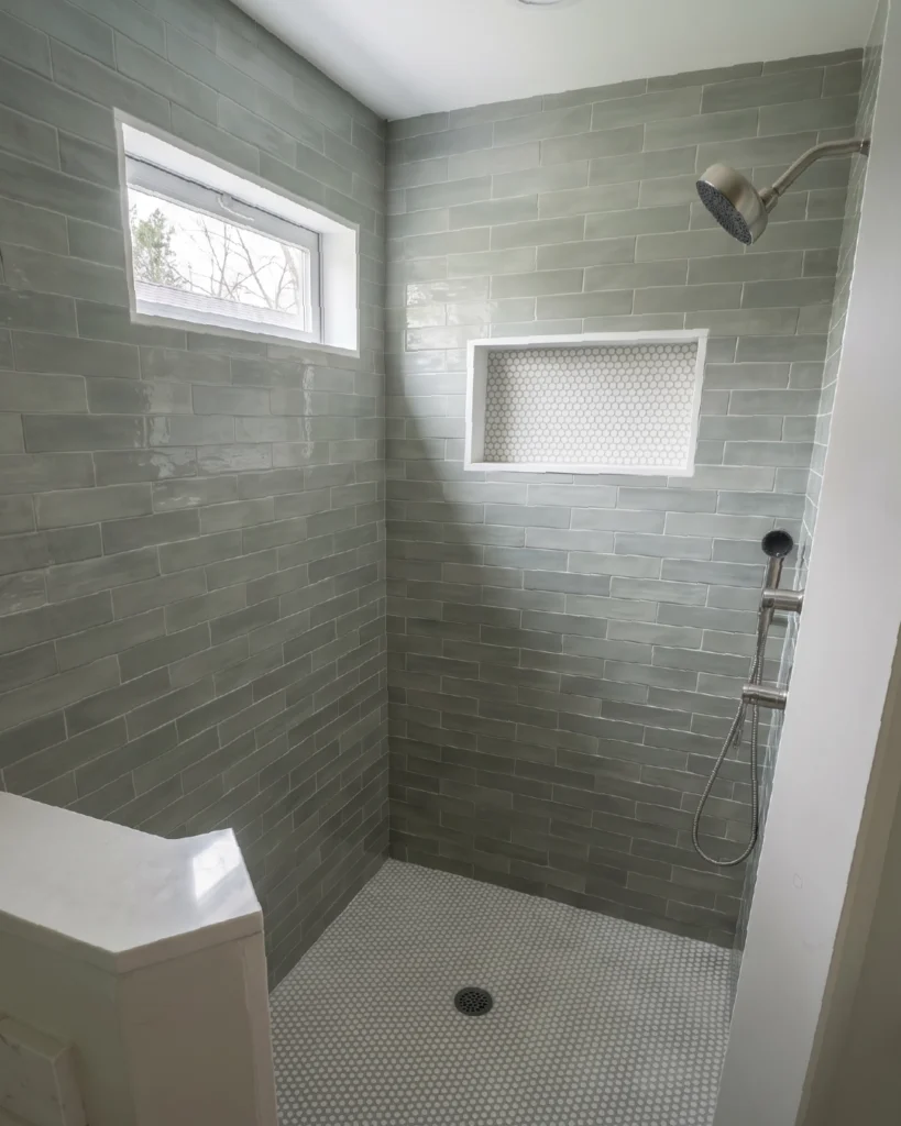 Walk-in shower with green subway tile, window and recessed niche