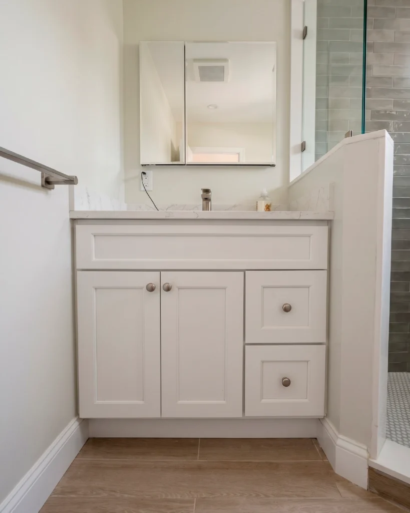 White shaker vanity beside a glass shower enclosure