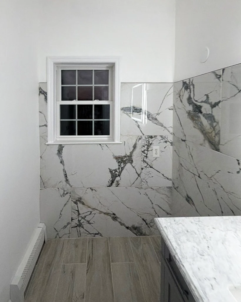 Bathroom with marble-look wall panels and white window