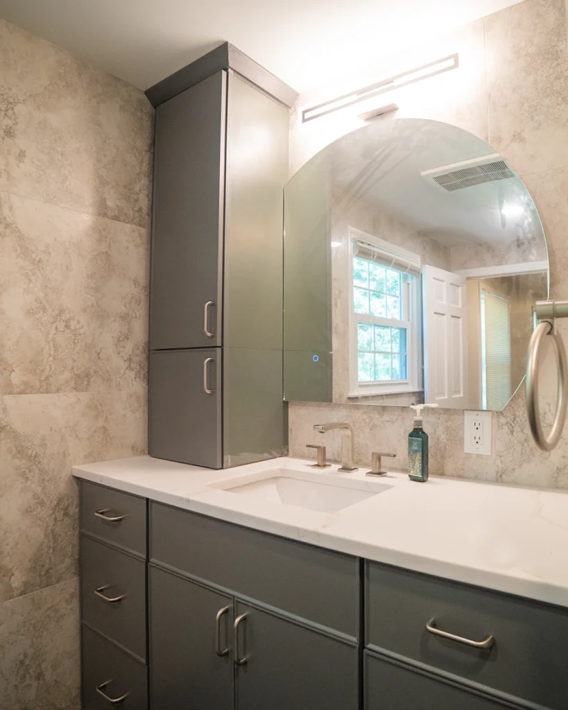 Gray double vanity with tall linen cabinet and arched mirror