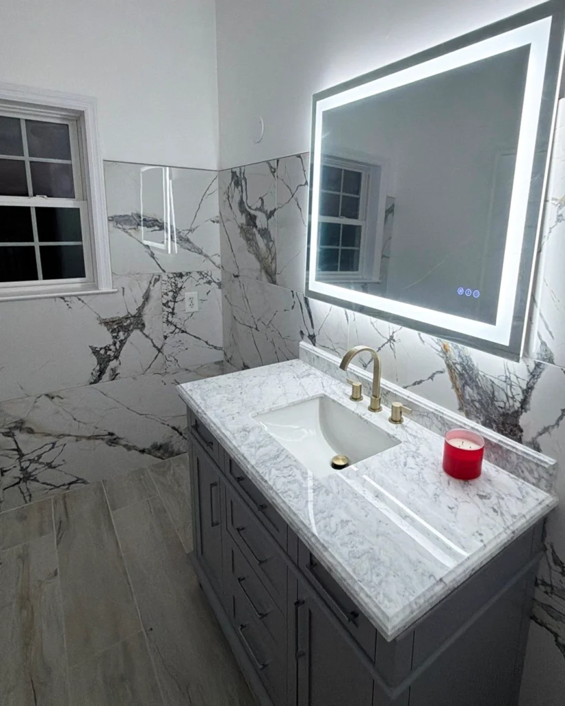 Gray vanity with marble top and backlit LED mirror