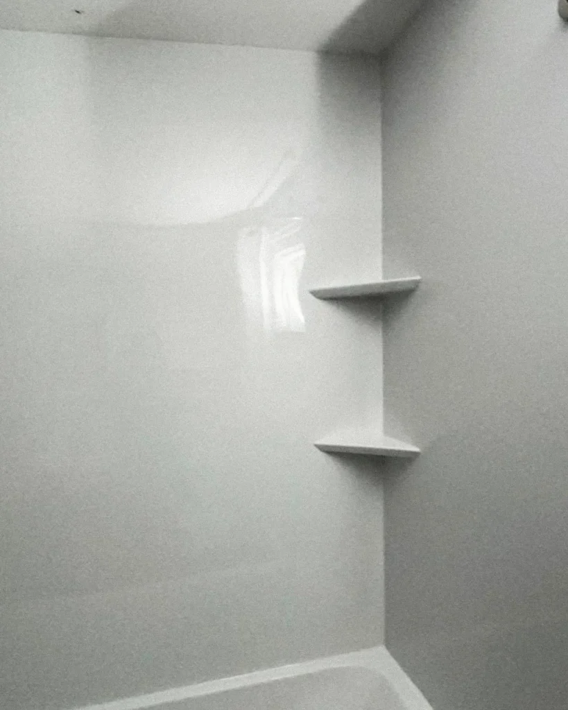 White shower surround with built-in corner shelves